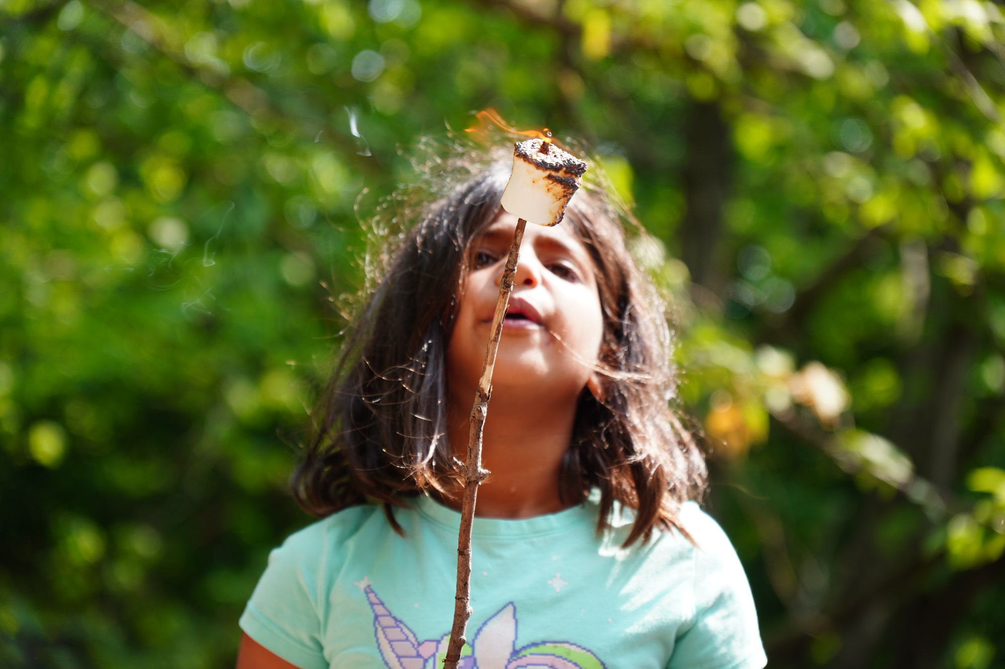 A child blows on a roasted marshmallow